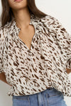 Oversized fit with flowing movement

Ruffle collar and elastic cuffs for added shape

Subtle v-neckline with easy pull-on design

Chocolate-toned animal print for a bold yet elevated look

Crafted from a breathable Tencel, linen, and nylon blend
