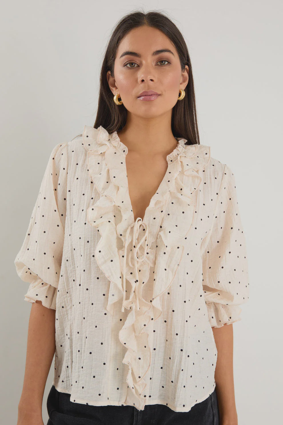 - 75% viscose, 15% linen, 10% polyester for a soft, airy feel
- Mid-length sleeves with gentle volume
- Button front with feminine tie and ruffle detail
- Classic spot print for playful versatility
- Delicate fabric, best cared for gently