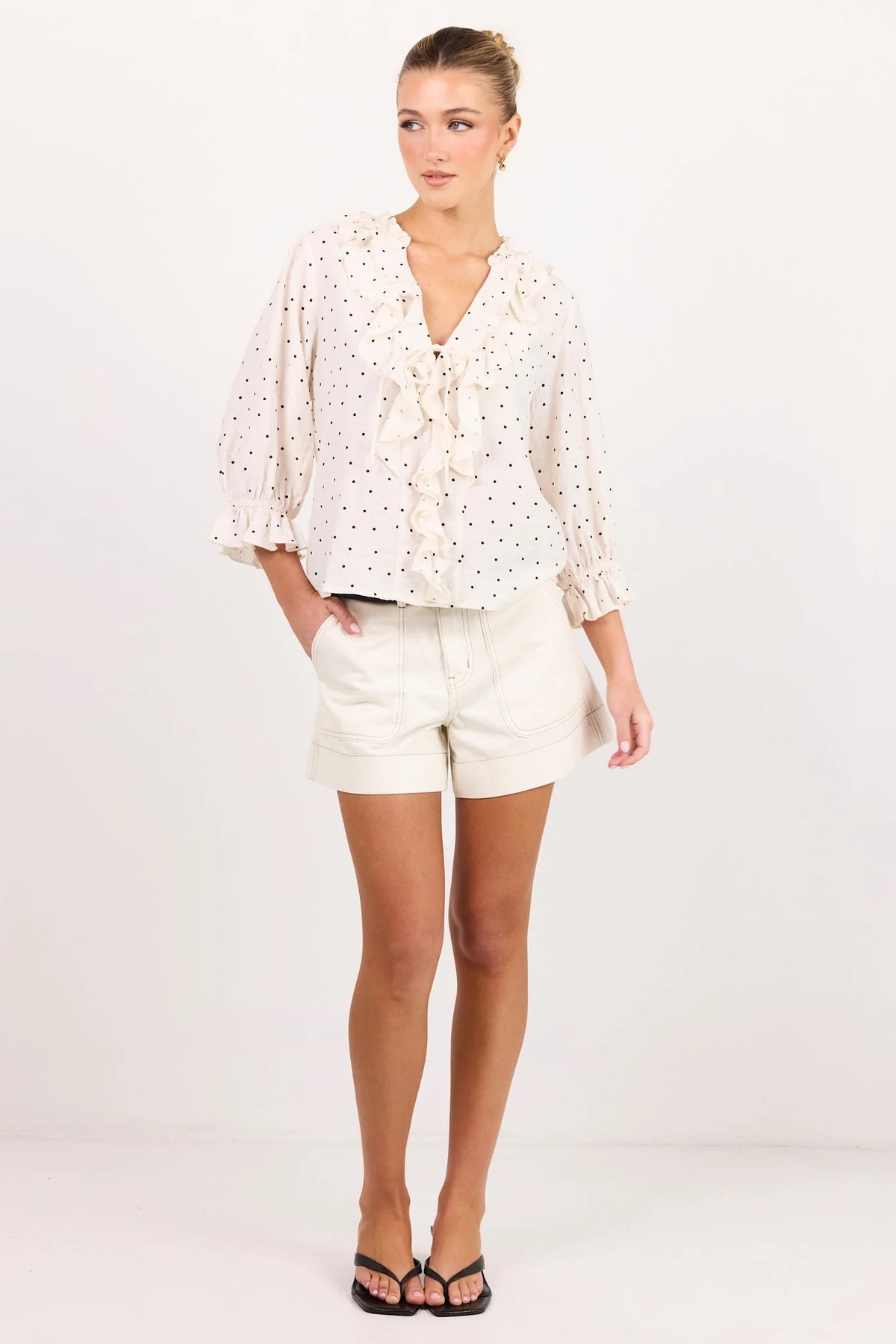 - 75% viscose, 15% linen, 10% polyester for a soft, airy feel
- Mid-length sleeves with gentle volume
- Button front with feminine tie and ruffle detail
- Classic spot print for playful versatility
- Delicate fabric, best cared for gently