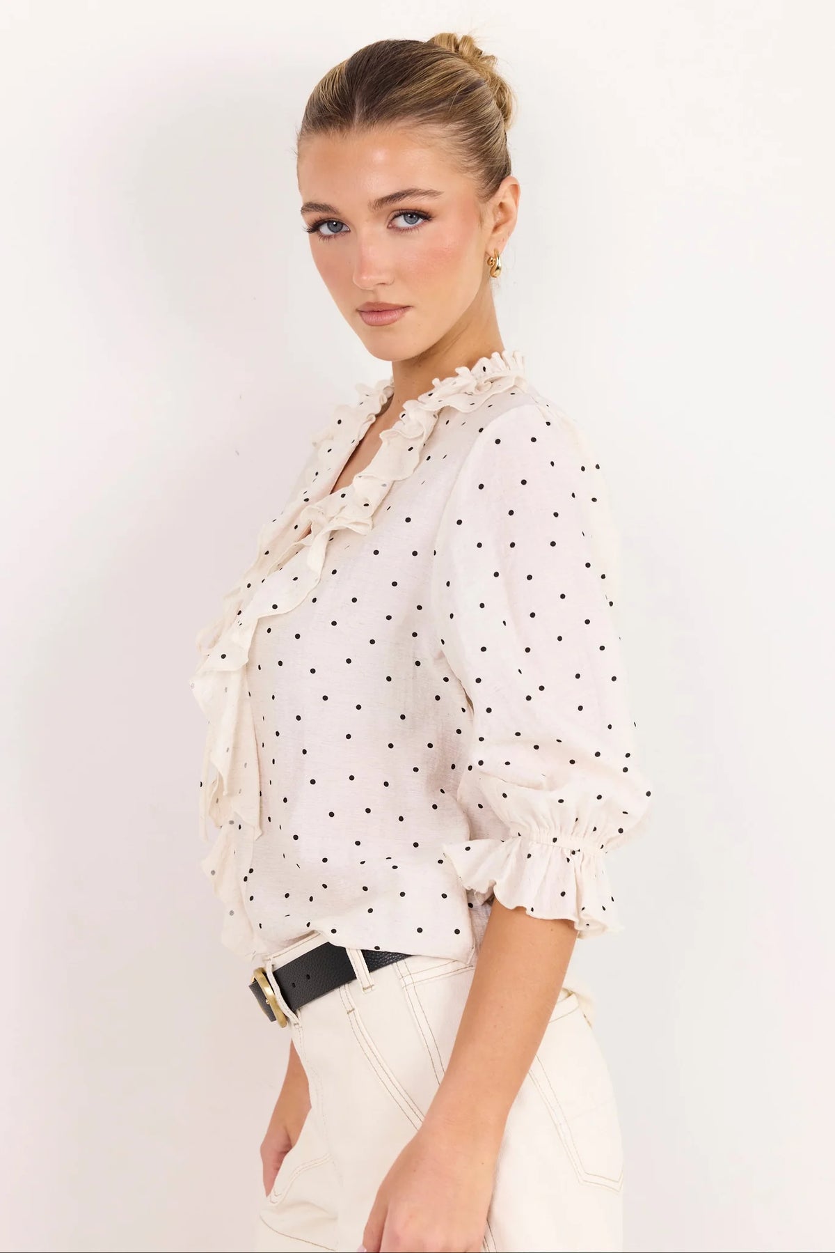 - 75% viscose, 15% linen, 10% polyester for a soft, airy feel
- Mid-length sleeves with gentle volume
- Button front with feminine tie and ruffle detail
- Classic spot print for playful versatility
- Delicate fabric, best cared for gently