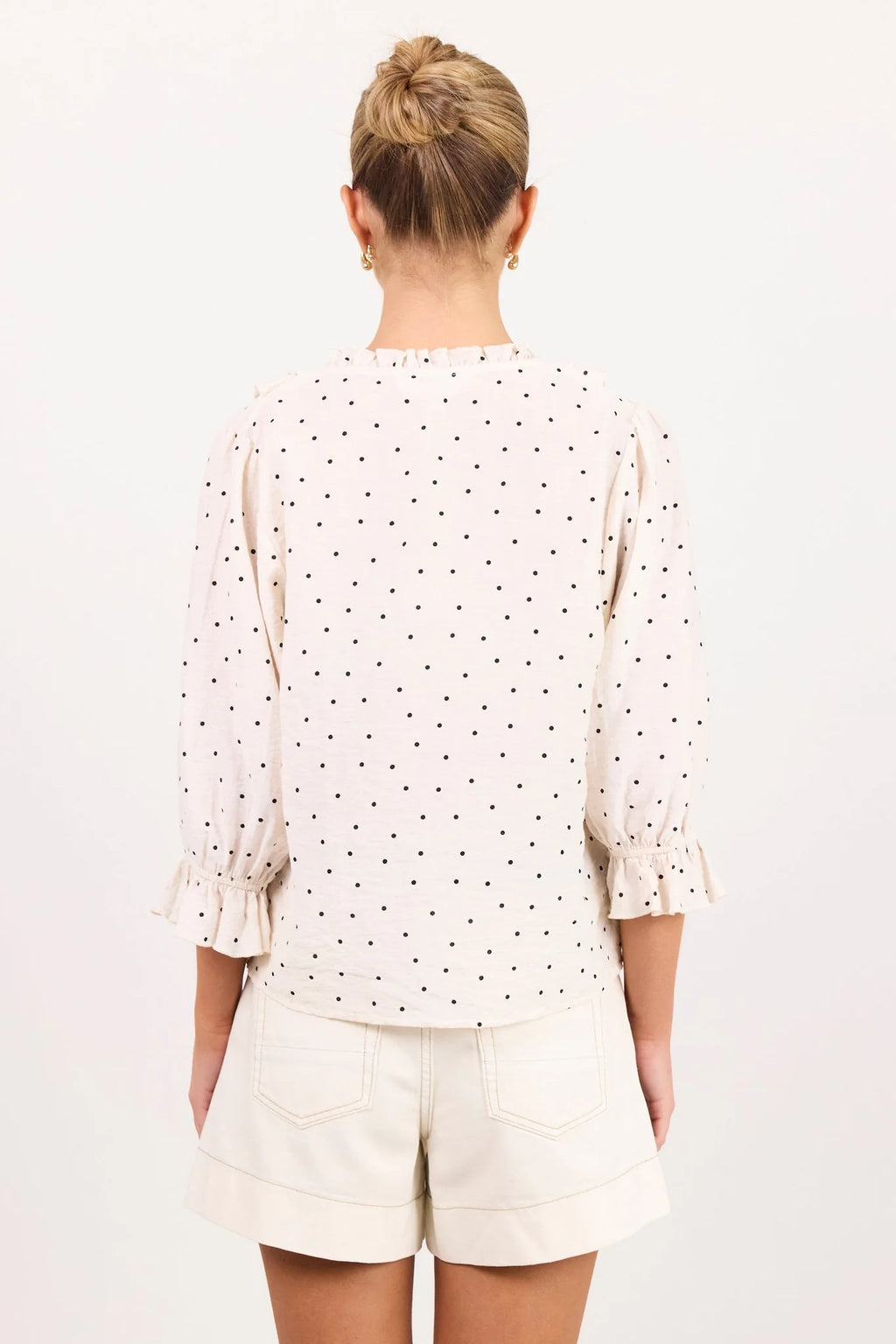 - 75% viscose, 15% linen, 10% polyester for a soft, airy feel
- Mid-length sleeves with gentle volume
- Button front with feminine tie and ruffle detail
- Classic spot print for playful versatility
- Delicate fabric, best cared for gently
