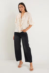 The Garnish top combines effortless charm with a playful touch. Featuring soft mid sleeves, a button front, and delicate ruffle trim, it offers subtle romantic details. The cream base adorned with black spots ensures a timeless yet lively look, while the lightweight fabric blend provides a graceful, flattering drape.