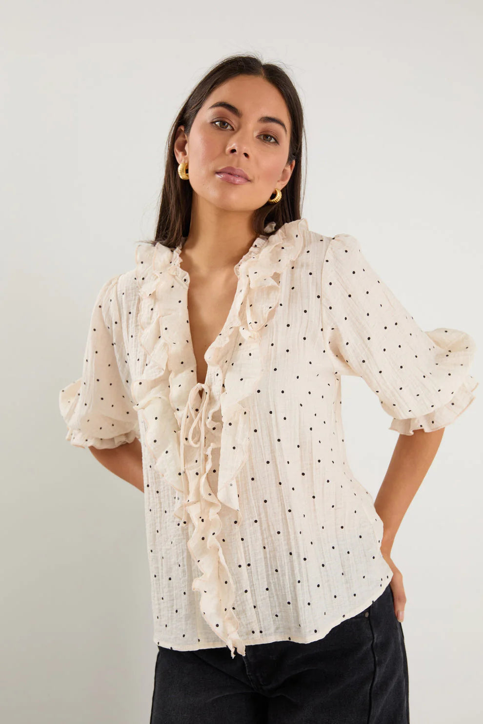 - 75% viscose, 15% linen, 10% polyester for a soft, airy feel
- Mid-length sleeves with gentle volume
- Button front with feminine tie and ruffle detail
- Classic spot print for playful versatility
- Delicate fabric, best cared for gently