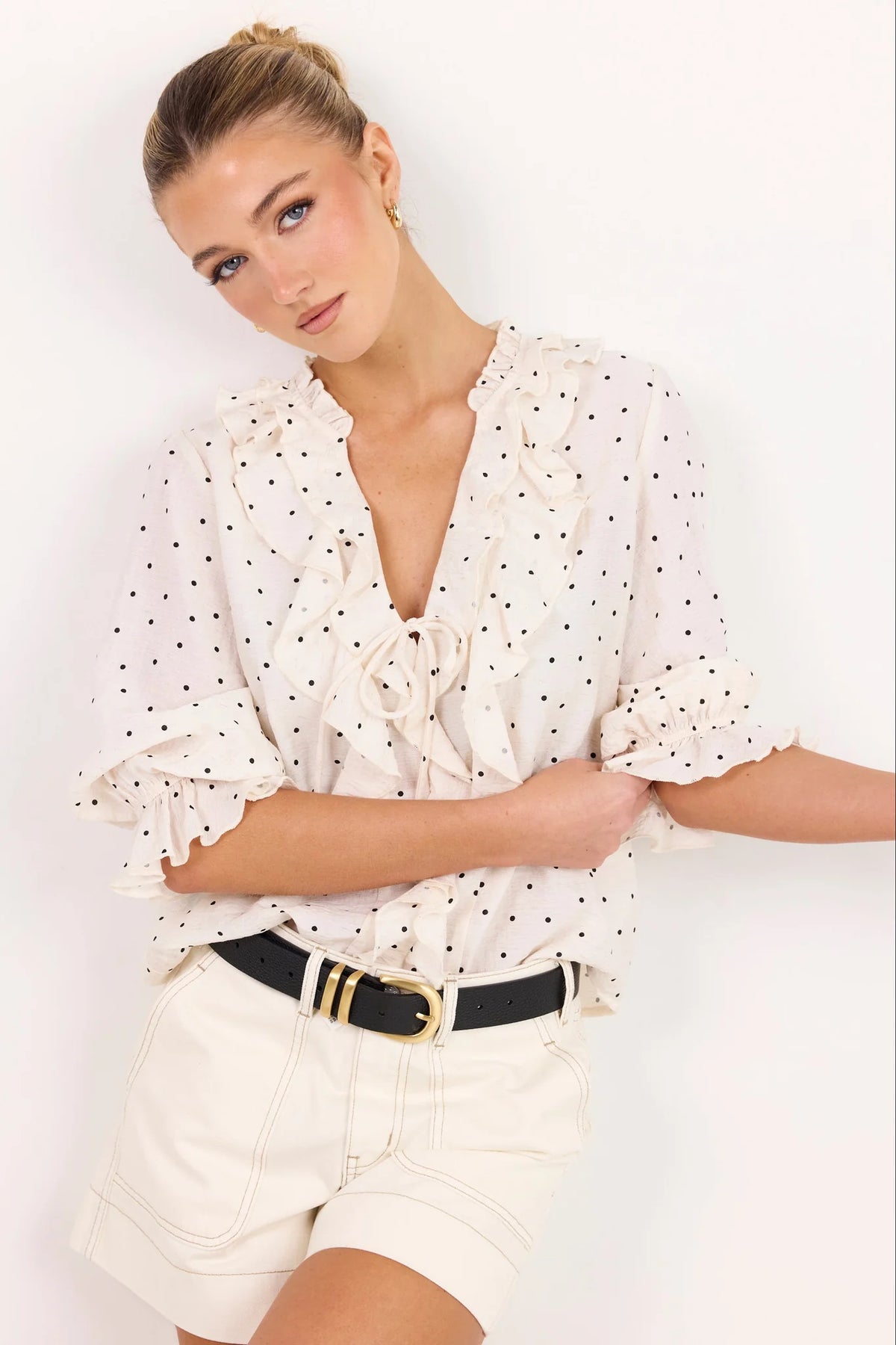 - 75% viscose, 15% linen, 10% polyester for a soft, airy feel
- Mid-length sleeves with gentle volume
- Button front with feminine tie and ruffle detail
- Classic spot print for playful versatility
- Delicate fabric, best cared for gently