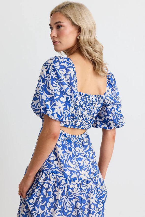 Make a statement in the Tranquillity Blue Batik Cut Out Tiered Midi Dress. With its shirred cut out back and flattering tiered design, this dress is perfect for any occasion. Elegant puff sleeves and a lightweight viscose blend add a touch of summer sophistication. Get ready to turn heads! Team up with your fav sandals for a summer outfit or add a heel for that special event.