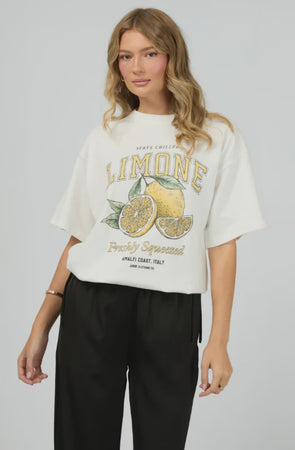 Brighten your day with the Jorge Limone Tee in Vintage White! This cool, relaxed tee features a classic crew neckline and playful vintage-style lemon graphic that’s bursting with personality. Short sleeves with extended shoulders and a straight hem complete the easy oversized fit. Perfect for sunny days—team it with denim shorts for a timeless summer vibe, or mix with wide-leg trousers and sandals to step up your casual style. Made from 100% cotton, it’s as comfy as it is fun!