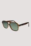 Bringing a modern twist to a '70s classic, the Kiki sunglasses from Otra offer an upgraded take on the traditional flat tops. These shades sport a rounded aviator shape and full framing, offering a contemporary spin. With a sturdy brow and gracefully curved edges, the Kiki is a medium fit, becoming a go-to choice for those seeking timeless style with a fresh twist.