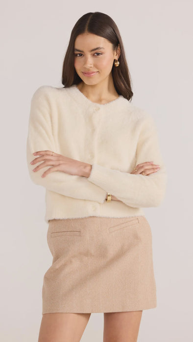 Introducing the Rowan Fluffy Cardi in ivory, a cozy and feminine addition to your wardrobe. Crafted from a super-soft, brushed knit, this timeless cardigan exudes effortless refinement. Wear it over a slip dress, with denim, or pair it with a Mini Skirt for a sophisticated mix of texture and polish.
