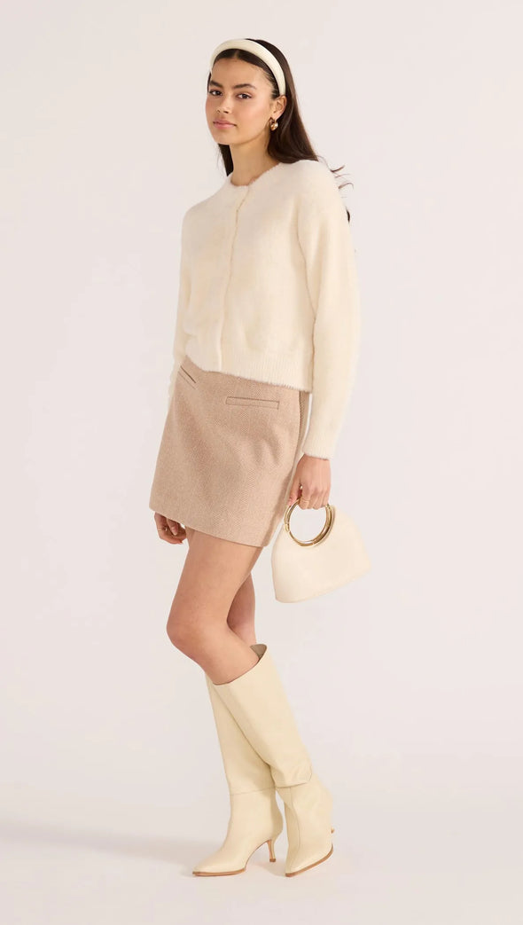 Introducing the Rowan Fluffy Cardi in ivory, a cozy and feminine addition to your wardrobe. Crafted from a super-soft, brushed knit, this timeless cardigan exudes effortless refinement. Wear it over a slip dress, with denim, or pair it with a Mini Skirt for a sophisticated mix of texture and polish.