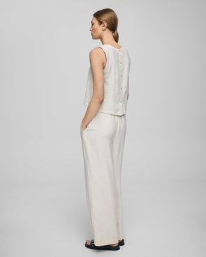 Regular fit

Model is 179cm and wears a size S

Lightweight, breathable summer fabric

Soft, eco-conscious viscose blend

Minimalist sleeveless design

Back button detail for a subtle finish

Composition

69% LENZING™ ECOVERO™ viscose fibers

20% Polyamide

11% Linen