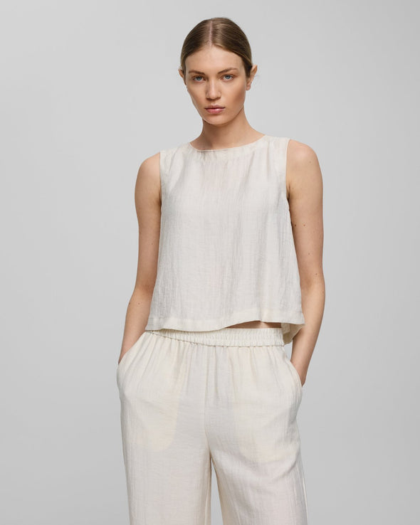 Regular fit

Model is 179cm and wears a size S

Lightweight, breathable summer fabric

Soft, eco-conscious viscose blend

Minimalist sleeveless design

Back button detail for a subtle finish

Composition

69% LENZING™ ECOVERO™ viscose fibers

20% Polyamide

11% Linen
