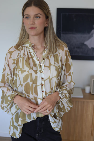 shirt featuring a stylish geometrical print in gold. The bellow sleeve detail adds a touch of elegance, and the elasticated cuffs allow you to wear them down or pushed up