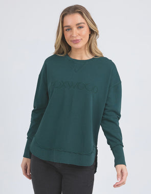 Add a pop of colour to your casual wardrobe with the Foxwood Simplified Crew in Forest Green. This vibrant crew is the ultimate layering piece, designed to bring both comfort and style to your everyday outfits. Featuring a relaxed round neckline, a flattering hi-lo hemline with side splits, and trendy raw edge detailing, this crew offers an effortlessly cool vibe. The embroidered Foxwood logo on the chest adds a touch of signature style, making this a go-to piece for any casual look.

Made from 100% cotton,