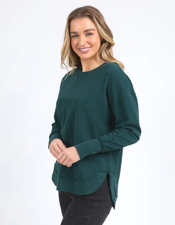 Add a pop of colour to your casual wardrobe with the Foxwood Simplified Crew in Forest Green. This vibrant crew is the ultimate layering piece, designed to bring both comfort and style to your everyday outfits. Featuring a relaxed round neckline, a flattering hi-lo hemline with side splits, and trendy raw edge detailing, this crew offers an effortlessly cool vibe. The embroidered Foxwood logo on the chest adds a touch of signature style, making this a go-to piece for any casual look.

Made from 100% cotton,