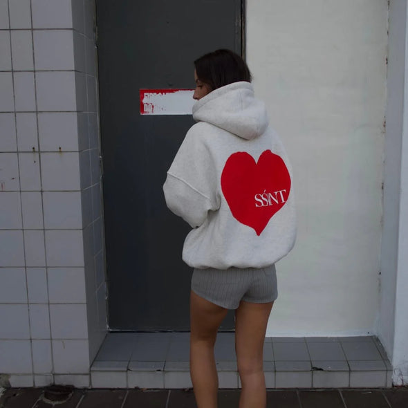 Elevate your off-duty style with the SŚAINT Grey Heart Hoodie – where comfort meets bold design. Crafted from a soft and durable 50% cotton, 50% polyester blend, this fleece-lined hoodie is the perfect throw-on for cooler days.