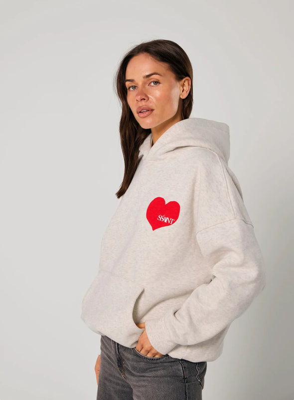 Elevate your off-duty style with the SŚAINT Grey Heart Hoodie – where comfort meets bold design. Crafted from a soft and durable 50% cotton, 50% polyester blend, this fleece-lined hoodie is the perfect throw-on for cooler days.