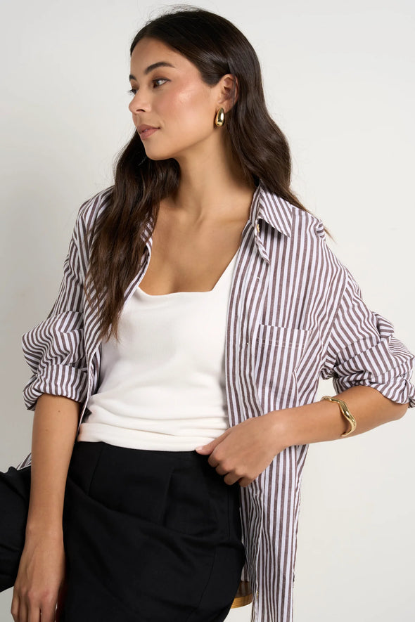 Effortlessly elevate your style with our fresh take on a classic button-up. The modern chocolate and white pinstripes add a touch of sophistication, while the lightweight fabric keeps you comfortable. Whether worn loose or tucked in, this versatile shirt is perfect for both polished office wear and casual weekends.