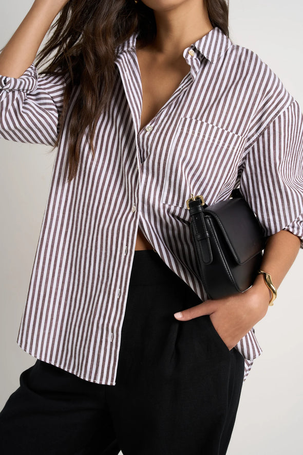 Effortlessly elevate your style with our fresh take on a classic button-up. The modern chocolate and white pinstripes add a touch of sophistication, while the lightweight fabric keeps you comfortable. Whether worn loose or tucked in, this versatile shirt is perfect for both polished office wear and casual weekends.