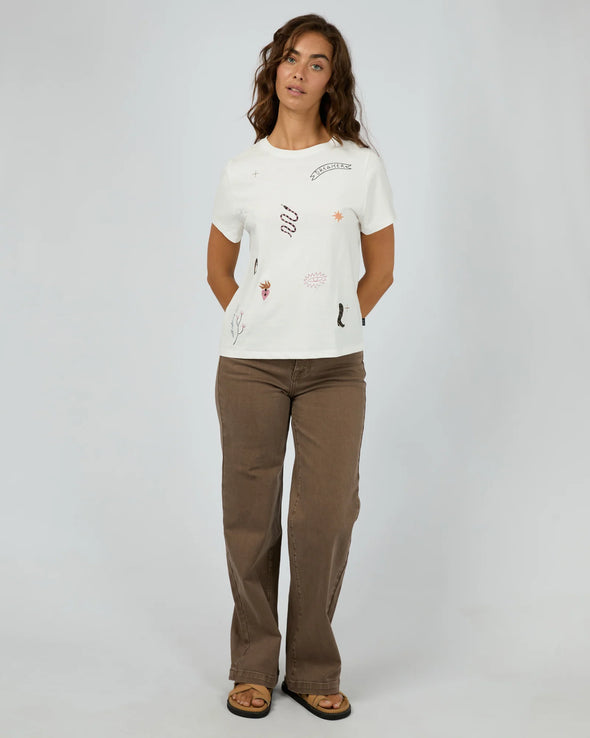 The Western Dreamer Regular Tee captures laid-back desert vibes with its crisp white fabric and playful western stamp-style prints. Its relaxed fit is perfect for tucking into denim cutoffs or layering under a slip dress, adding a subtle touch of western charm to your everyday style. Effortlessly cool and ready for any adventure!