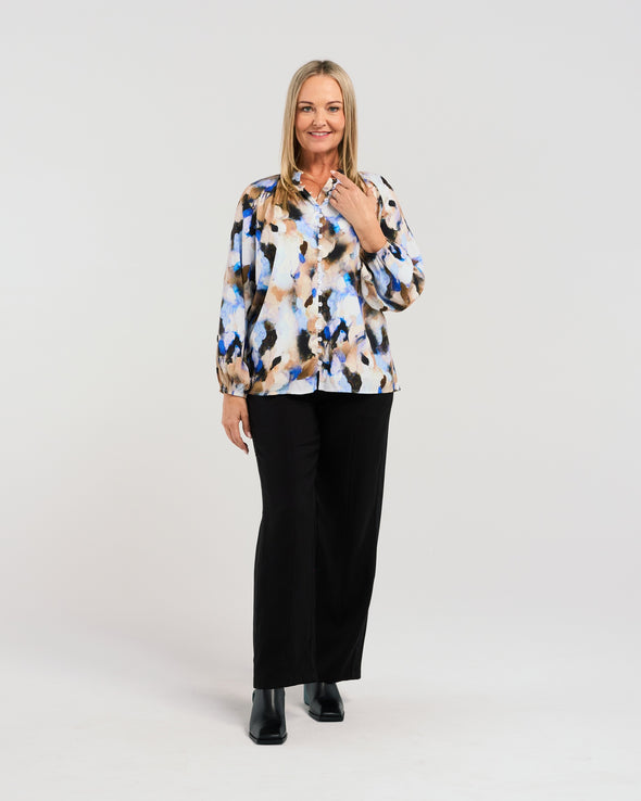 Indulge in the eye-catching appeal of our vibrant blouse. The stunning fabric boasts beautiful blue hues, while the button-down front and elasticated sleeves add a touch of chic functionality. Elevate your style with this fresh, luxurious piece.