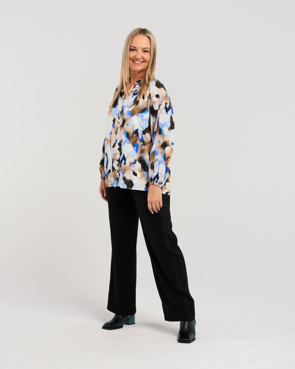 Indulge in the eye-catching appeal of our vibrant blouse. The stunning fabric boasts beautiful blue hues, while the button-down front and elasticated sleeves add a touch of chic functionality. Elevate your style with this fresh, luxurious piece.