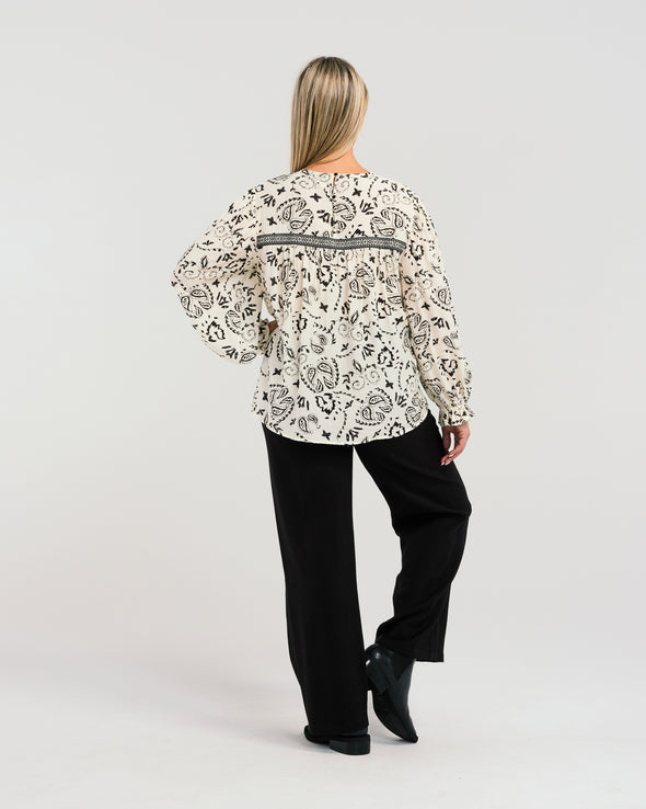 Indulge in the luxurious comfort of our chic top, featuring a relaxed fit, long sleeves, and a round neckline. The gorgeous print fabric is accented with delicate lace trim, adding a touch of elegance to your look. Perfect for any occasion, this top will keep you looking stylish and feeling comfortable all day long.