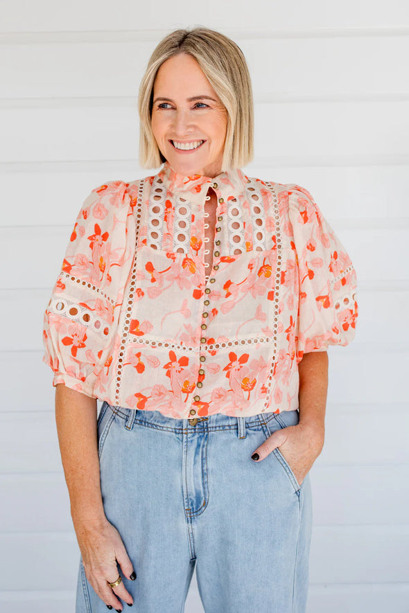 Circular lace trims and antique brass buttons bring a dash of romance to this effortlessly stylish top. The cabaret silhouette balances ornate details with everyday wearability, making it a playful favourite that adds high-impact charm without any fuss.
