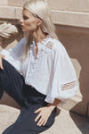 The Quell top embodies romance and vintage charm with its ruffled neckline and bodice, inset shoulder seam, and blouson sleeves. Crafted from lightweight, luxurious ramie, this top effortlessly transitions from day to night. Complete the look with denim or tailored pants for enviable style.