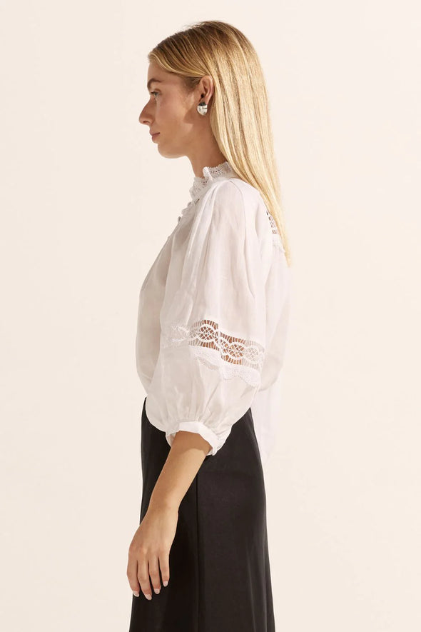 The Quell top embodies romance and vintage charm with its ruffled neckline and bodice, inset shoulder seam, and blouson sleeves. Crafted from lightweight, luxurious ramie, this top effortlessly transitions from day to night. Complete the look with denim or tailored pants for enviable style.