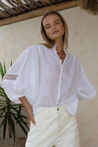 The Quell top embodies romance and vintage charm with its ruffled neckline and bodice, inset shoulder seam, and blouson sleeves. Crafted from lightweight, luxurious ramie, this top effortlessly transitions from day to night. Complete the look with denim or tailored pants for enviable style.