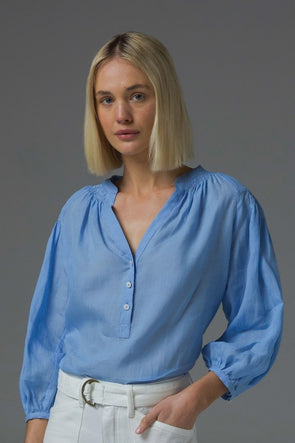 Elevate your style with the Stage Top. This blouse features a flattering V-neckline with soft shirring details, complemented by lightweight cross-dye ramie for all-day comfort. Contrasting shell buttons with gold accents add a touch of elegance, while three-quarter sleeves with rouleau loop button finish add a stylish touch.