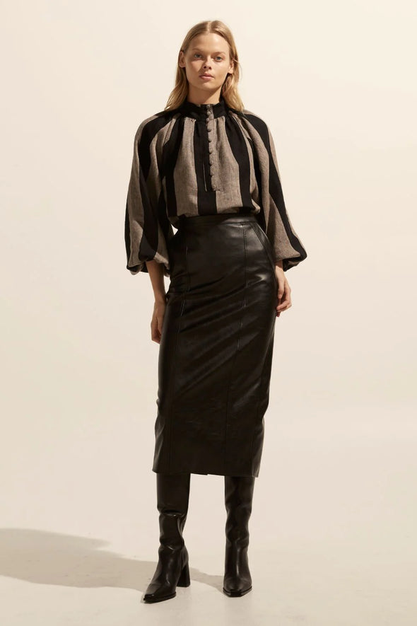 a vegan leather midi skirt, finishing mid-calf is the perfect length to pair with a knee-high boot. the tour's simple, straight-line structure nods to the classic asking to be balanced by a top with more feminine shape and movement. see product details below.